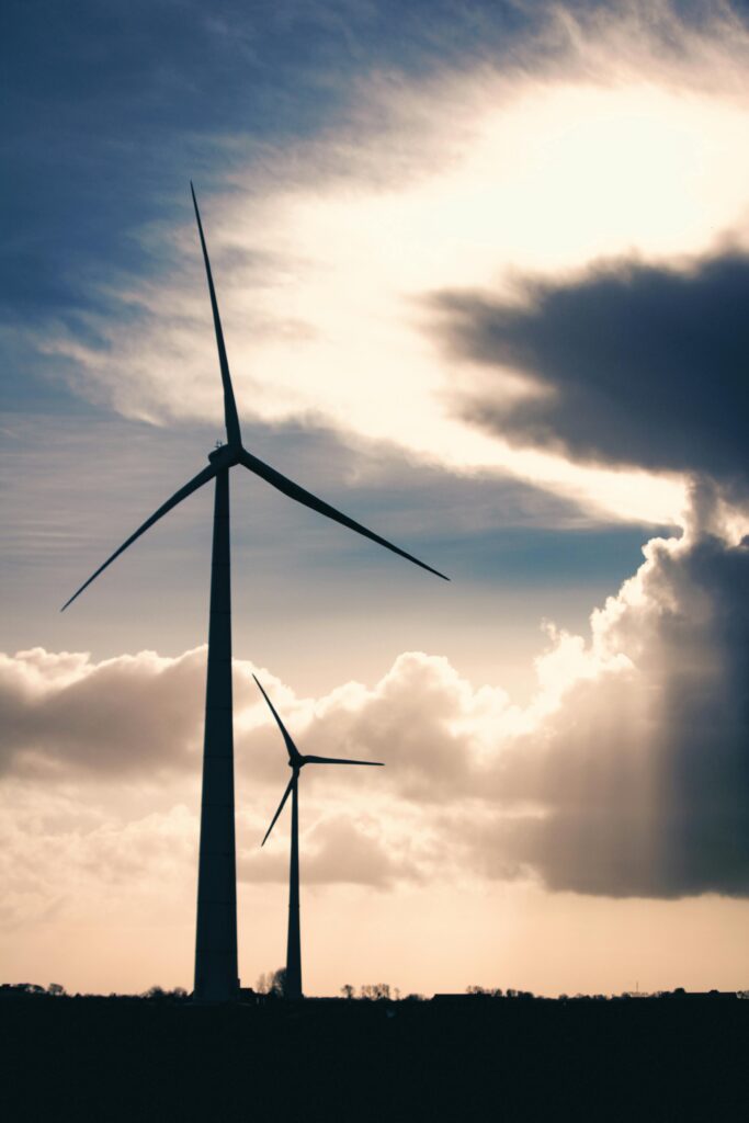 pexels-photo-735468-735468 Silhouettes of wind turbines against a cloudy, dramatic sky demonstrating renewable energy.